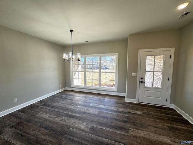 unfurnished dining area with a notable chandelier and dark hardwood / wood-style floors