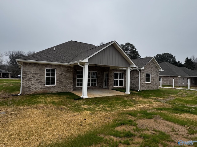 back of house featuring a patio area and a lawn