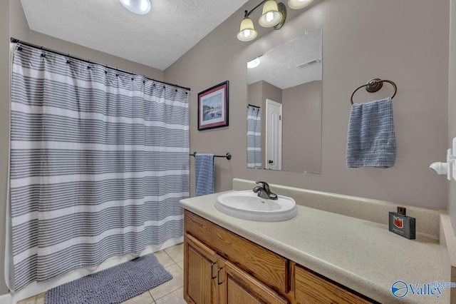 full bathroom featuring visible vents, tile patterned floors, vanity, and a textured ceiling
