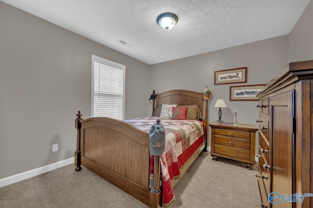 bedroom with light carpet, visible vents, a textured ceiling, and baseboards