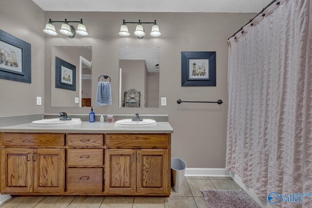 full bathroom with a sink, double vanity, and tile patterned flooring