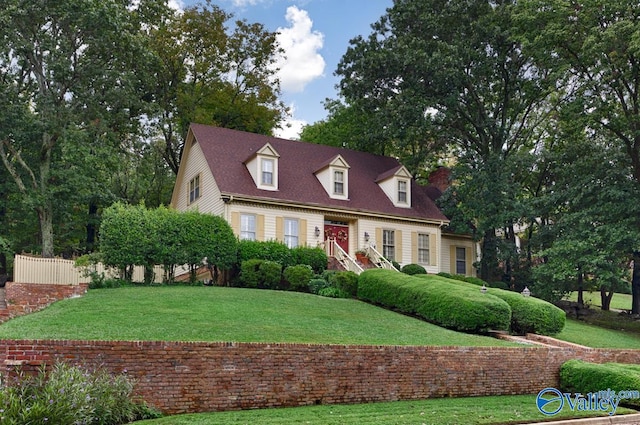 cape cod home with a front lawn