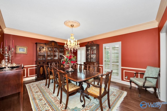 dining room featuring crown molding, dark wood-type flooring, and a notable chandelier