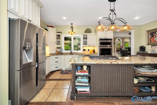 kitchen with appliances with stainless steel finishes, hanging light fixtures, white cabinetry, light stone countertops, and crown molding