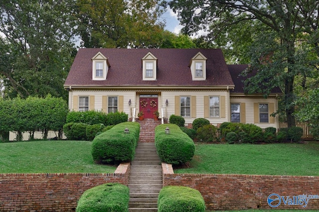 cape cod house featuring a front lawn