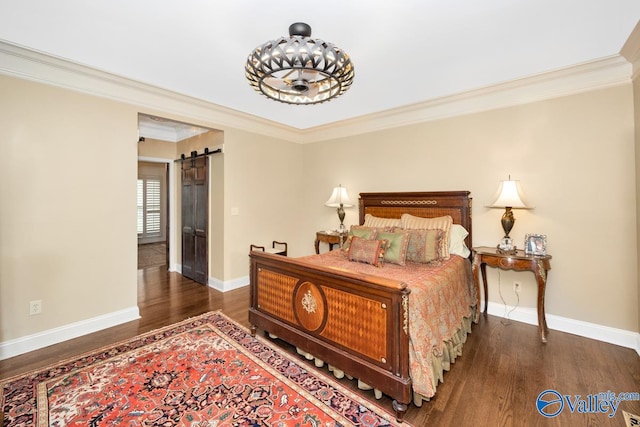 bedroom featuring ornamental molding, dark wood-type flooring, and a barn door