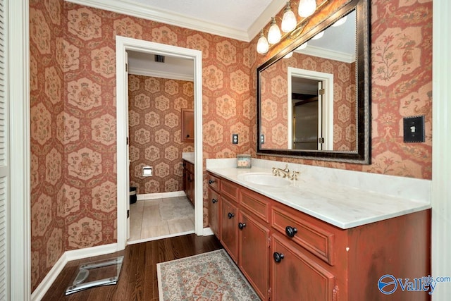 bathroom featuring ornamental molding, wood-type flooring, and vanity