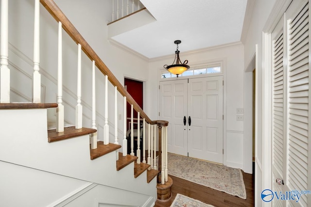 entryway with ornamental molding and hardwood / wood-style flooring