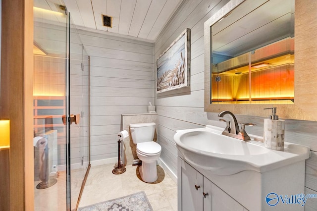 bathroom featuring wooden walls, a shower with shower door, vanity, and toilet