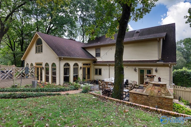 rear view of house with a patio, an outdoor living space, and a yard