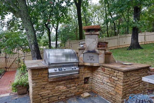 view of patio featuring an outdoor kitchen and a grill