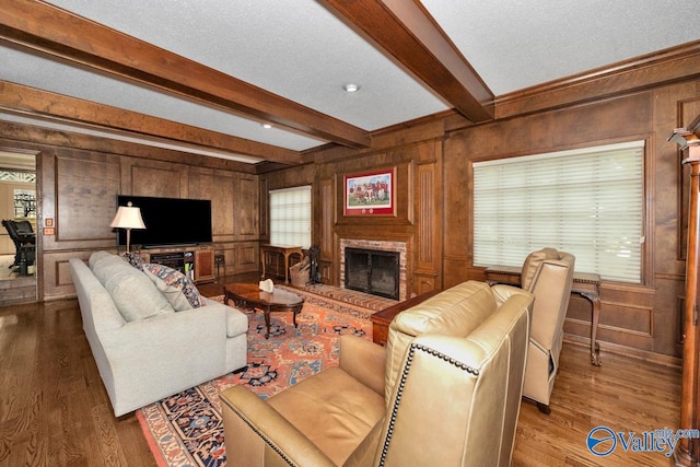 living room with wood-type flooring, wood walls, and beamed ceiling