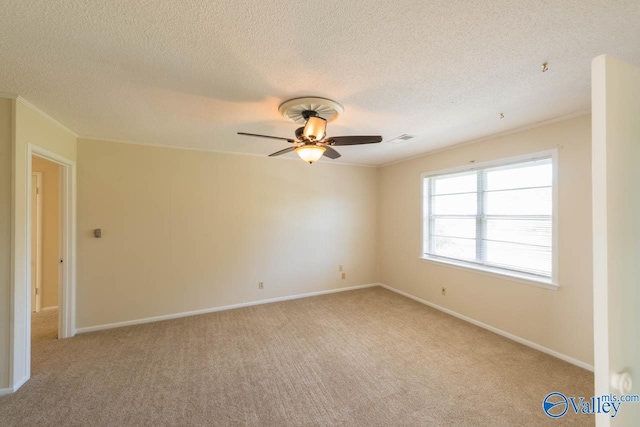 carpeted empty room featuring ornamental molding, a textured ceiling, and ceiling fan