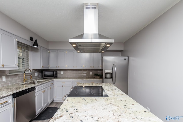 kitchen featuring tasteful backsplash, island exhaust hood, appliances with stainless steel finishes, and sink