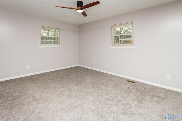 unfurnished room featuring plenty of natural light, carpet, and ceiling fan