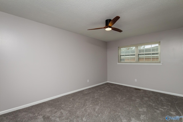 unfurnished room with ceiling fan, a textured ceiling, and dark colored carpet