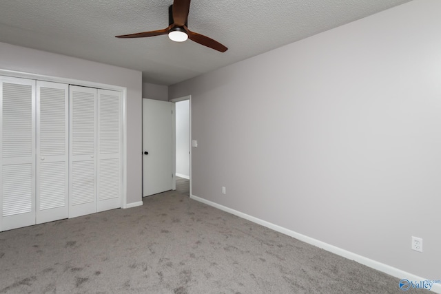 unfurnished bedroom with ceiling fan, light colored carpet, a textured ceiling, and a closet