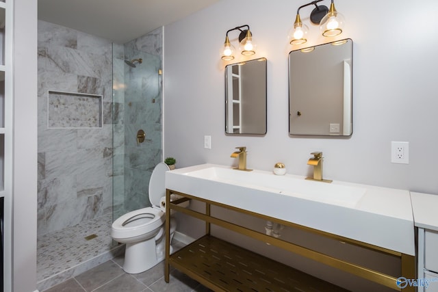 bathroom with vanity, a tile shower, tile patterned floors, and toilet