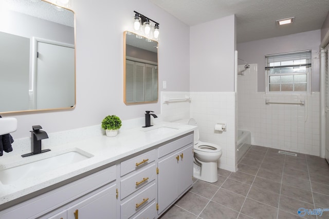 full bathroom with tile walls, tile patterned floors, toilet, and a textured ceiling