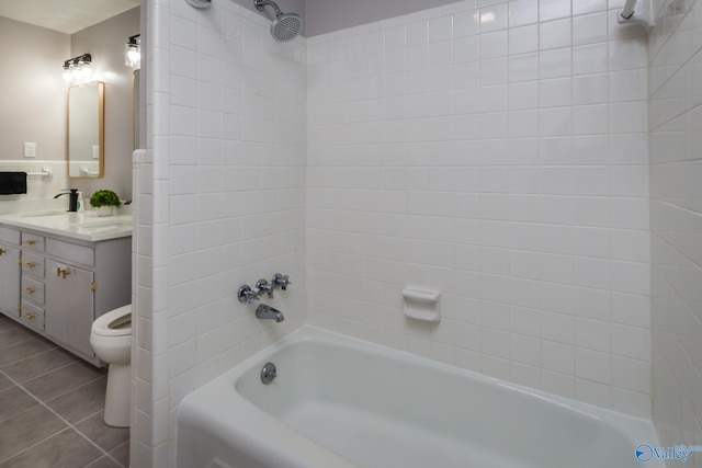 full bathroom featuring tiled shower / bath, vanity, toilet, and tile patterned flooring