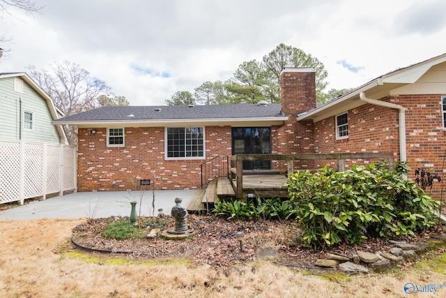 back of property featuring a wooden deck and a patio area