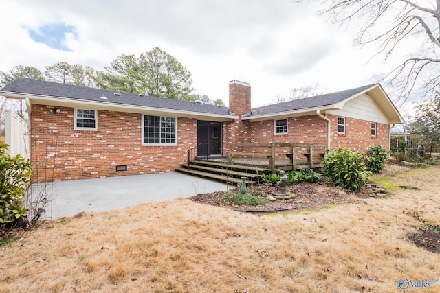 rear view of house featuring a wooden deck and a patio area