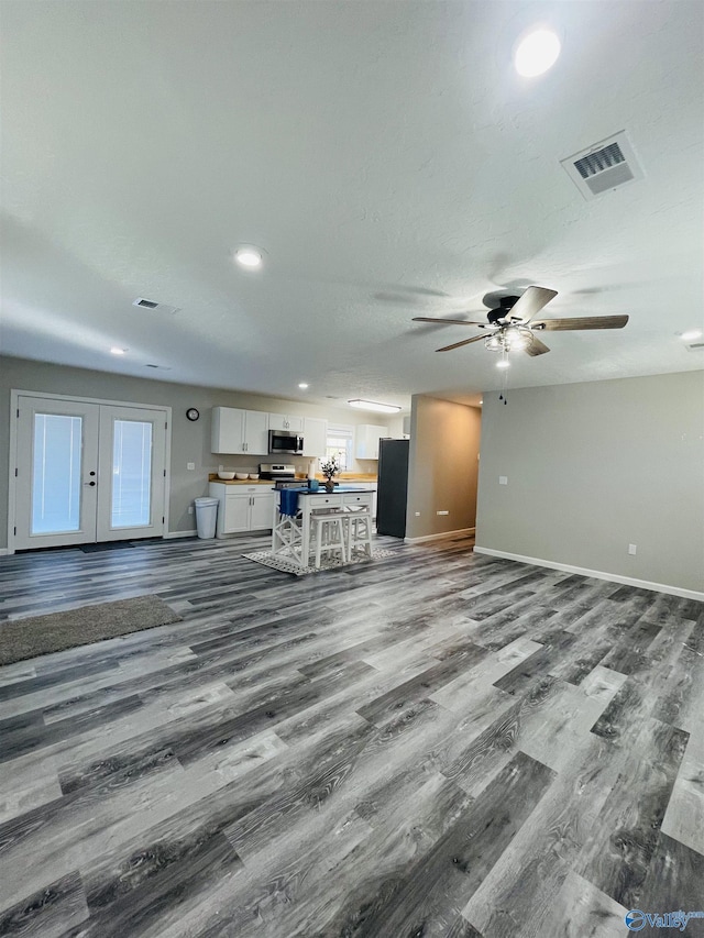 unfurnished living room featuring ceiling fan and wood-type flooring