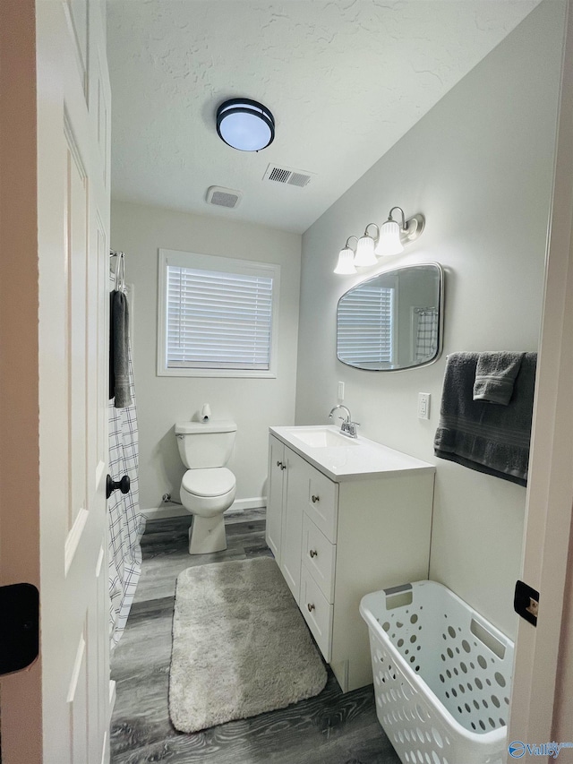 bathroom with hardwood / wood-style floors, vanity, and toilet