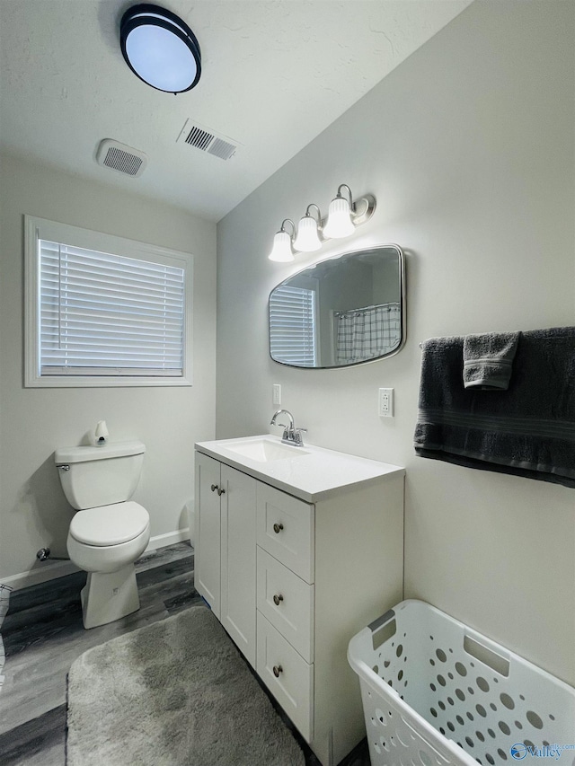 bathroom with curtained shower, toilet, vanity, and hardwood / wood-style flooring