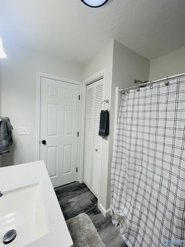 bathroom featuring a shower with curtain, vanity, and wood-type flooring