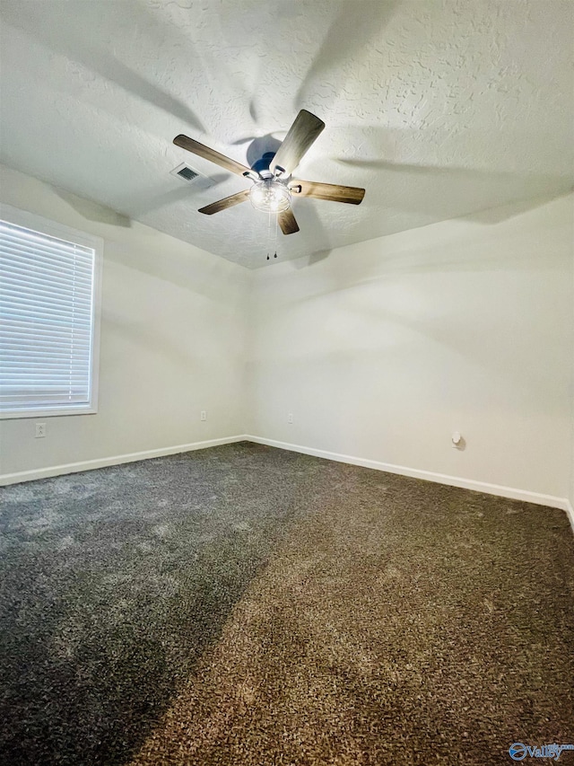 carpeted spare room with ceiling fan and a textured ceiling