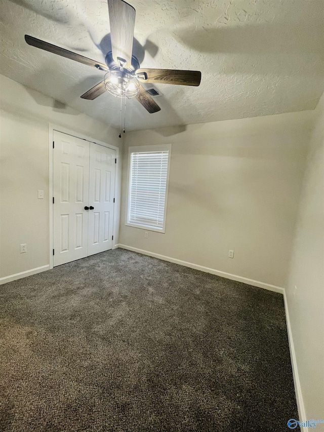 unfurnished bedroom with carpet, a textured ceiling, a closet, and ceiling fan