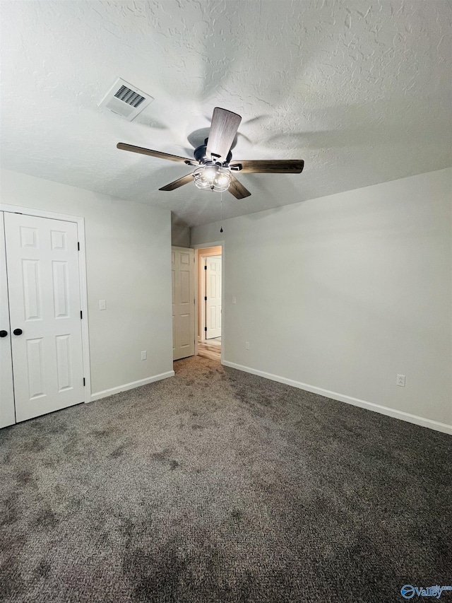 spare room featuring ceiling fan, carpet floors, and a textured ceiling