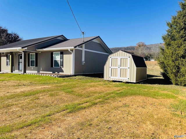 view of home's exterior with a yard, a porch, and a storage shed