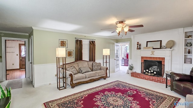 living room with crown molding, ceiling fan, a fireplace, carpet floors, and a textured ceiling