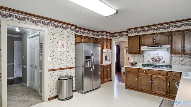 kitchen featuring white appliances, dark brown cabinets, ornamental molding, and a textured ceiling