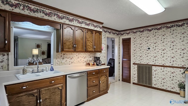 kitchen featuring sink, crown molding, stainless steel dishwasher, and a textured ceiling