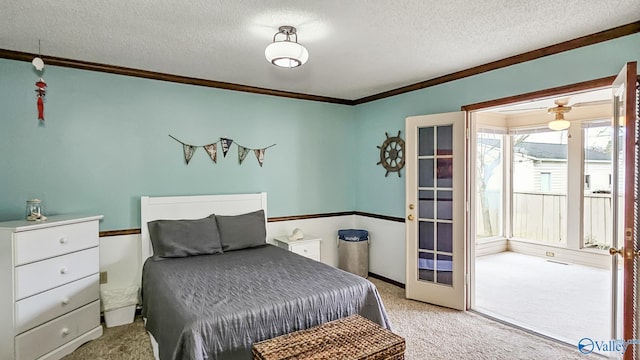 carpeted bedroom featuring french doors, ornamental molding, and a textured ceiling