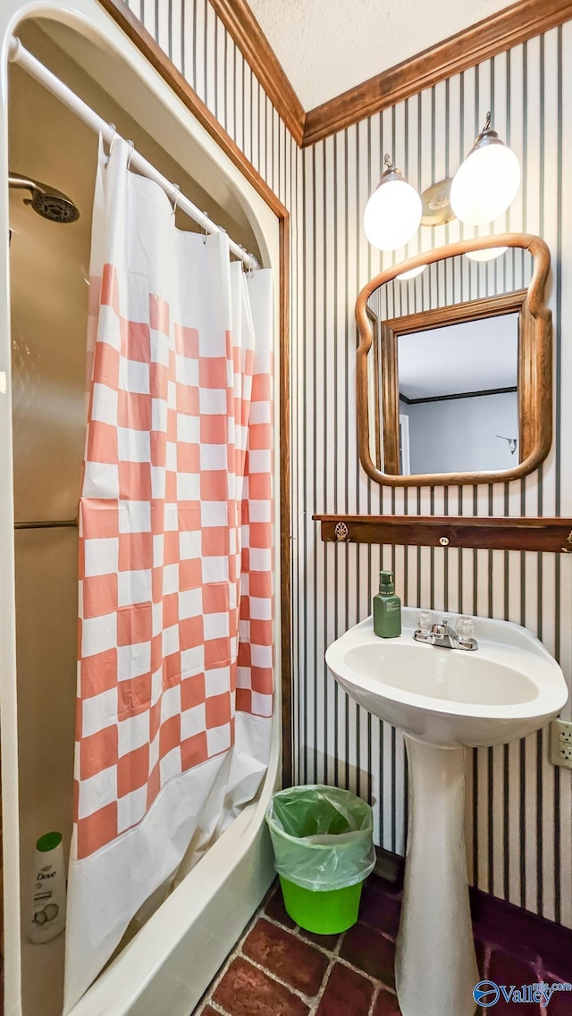 bathroom with ornamental molding, curtained shower, and sink