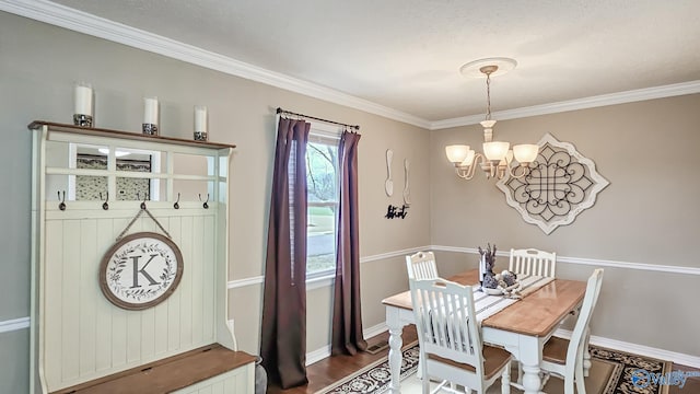 dining room featuring hardwood / wood-style flooring, ornamental molding, and a chandelier