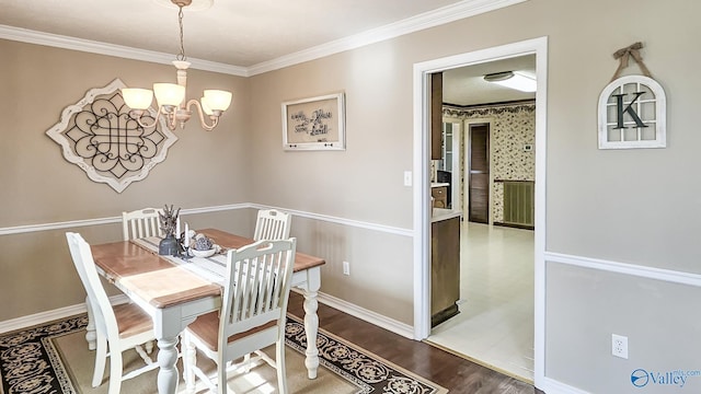 dining area featuring ornamental molding, hardwood / wood-style floors, and an inviting chandelier