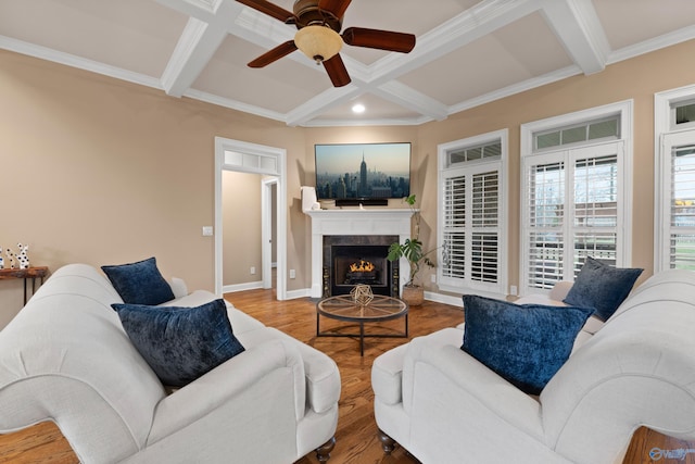 living room with a tile fireplace, beam ceiling, coffered ceiling, and wood finished floors