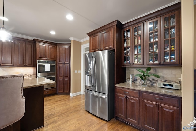 kitchen with light wood finished floors, glass insert cabinets, appliances with stainless steel finishes, ornamental molding, and dark brown cabinets