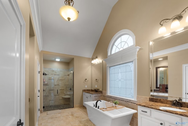 full bath with lofted ceiling, two vanities, a stall shower, a sink, and a freestanding tub