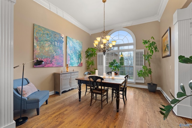 dining area with light wood-style floors, baseboards, a chandelier, and crown molding