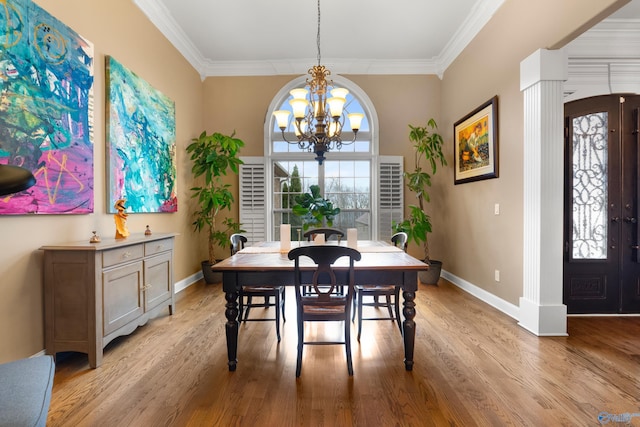 dining room featuring crown molding, light wood finished floors, a wealth of natural light, and a notable chandelier