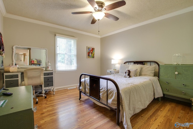bedroom with a textured ceiling, ornamental molding, baseboards, and wood finished floors