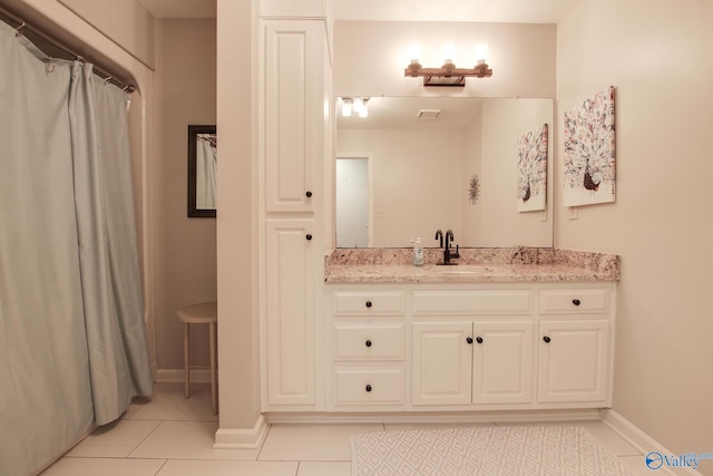 full bath with tile patterned floors, visible vents, baseboards, and vanity