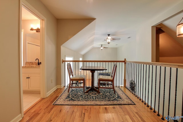 interior space with baseboards, a ceiling fan, lofted ceiling, and wood finished floors