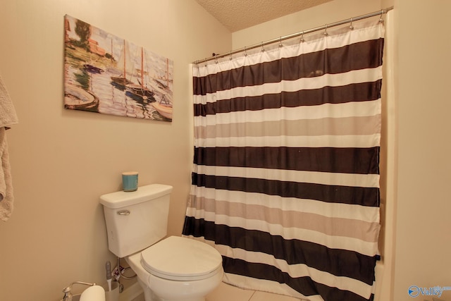 full bath with tile patterned floors, curtained shower, toilet, and a textured ceiling